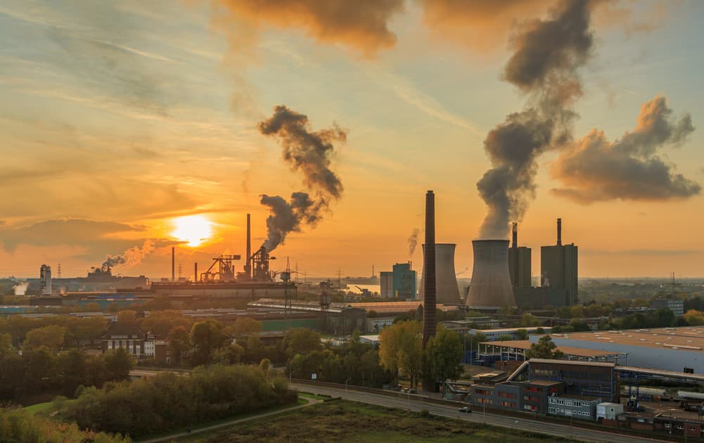 Rök från industri i solnedgång. Foto taget i Duisburg, Germany.